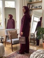 Sami Özdoğan penye pantolonlu tunik takım giyen bir kadın, şık ve konforlu büyük beden kadın tunik takım kombiniyle poz veriyor. Anneye hediye olarak da düşünülebilecek özel gün hediyesi.